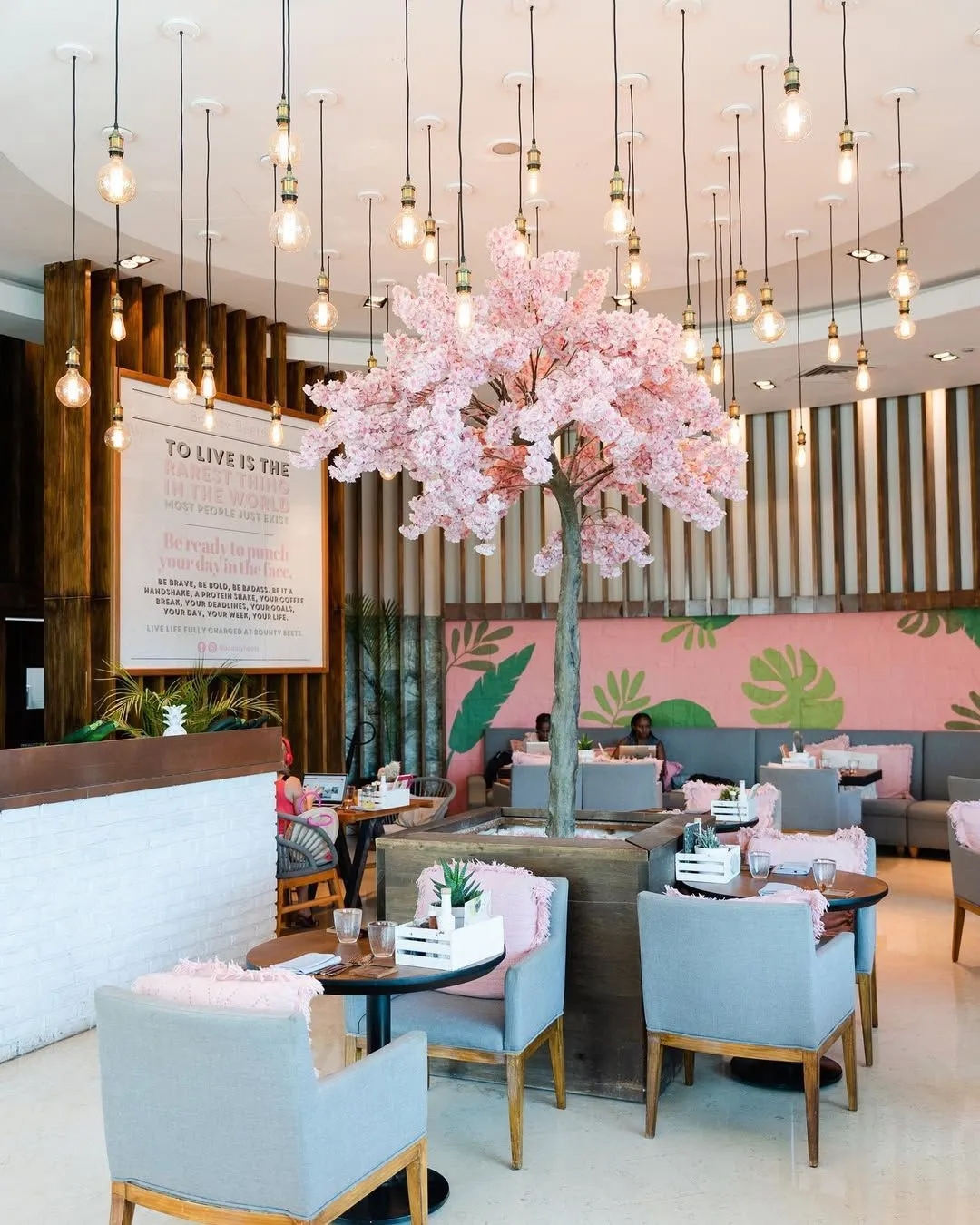 The pink and floral interior of Bounty Beets restaurant in Dubai featuring botanical decor.