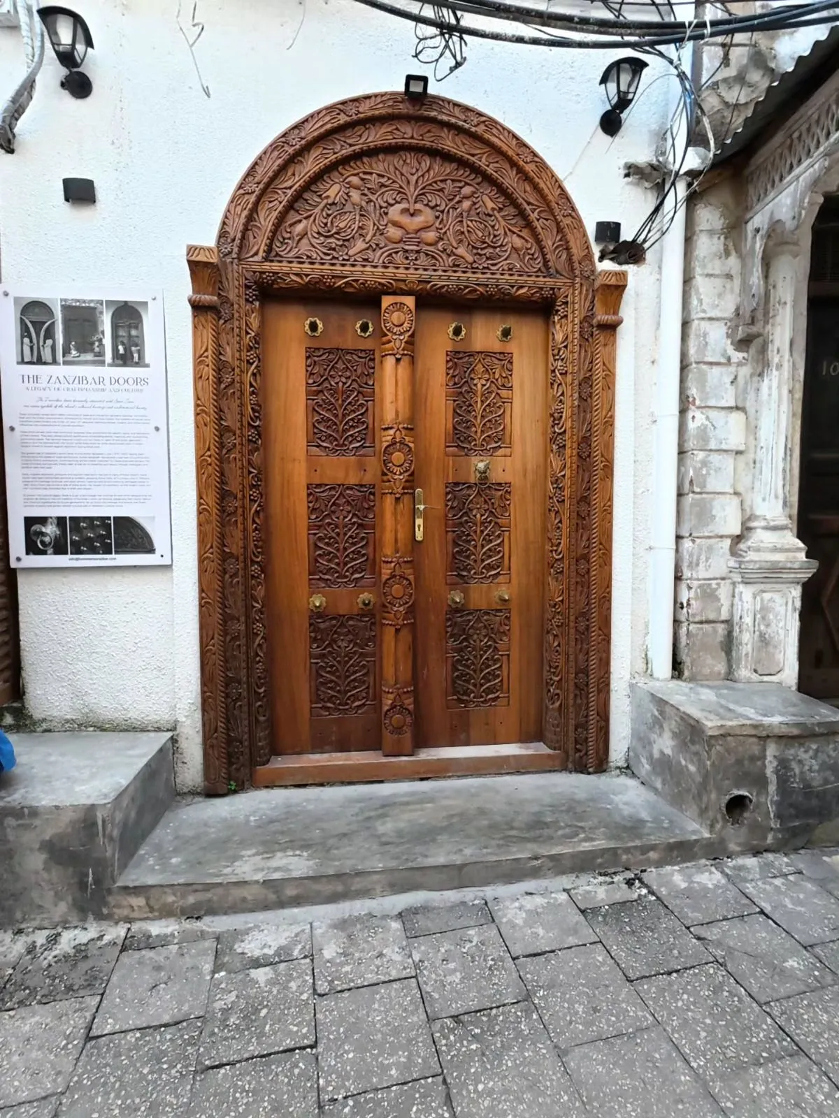 Intricate wooden carved door with brass studs in Stone Town Zanzibar