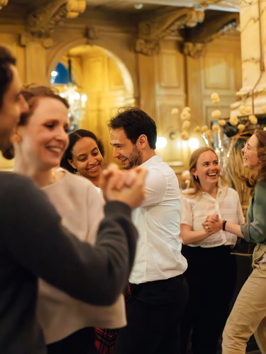 Families dining in a cozy, wood-paneled Edinburgh restaurant with stone walls and soft lighting as snow falls outside during New Year celebrations.