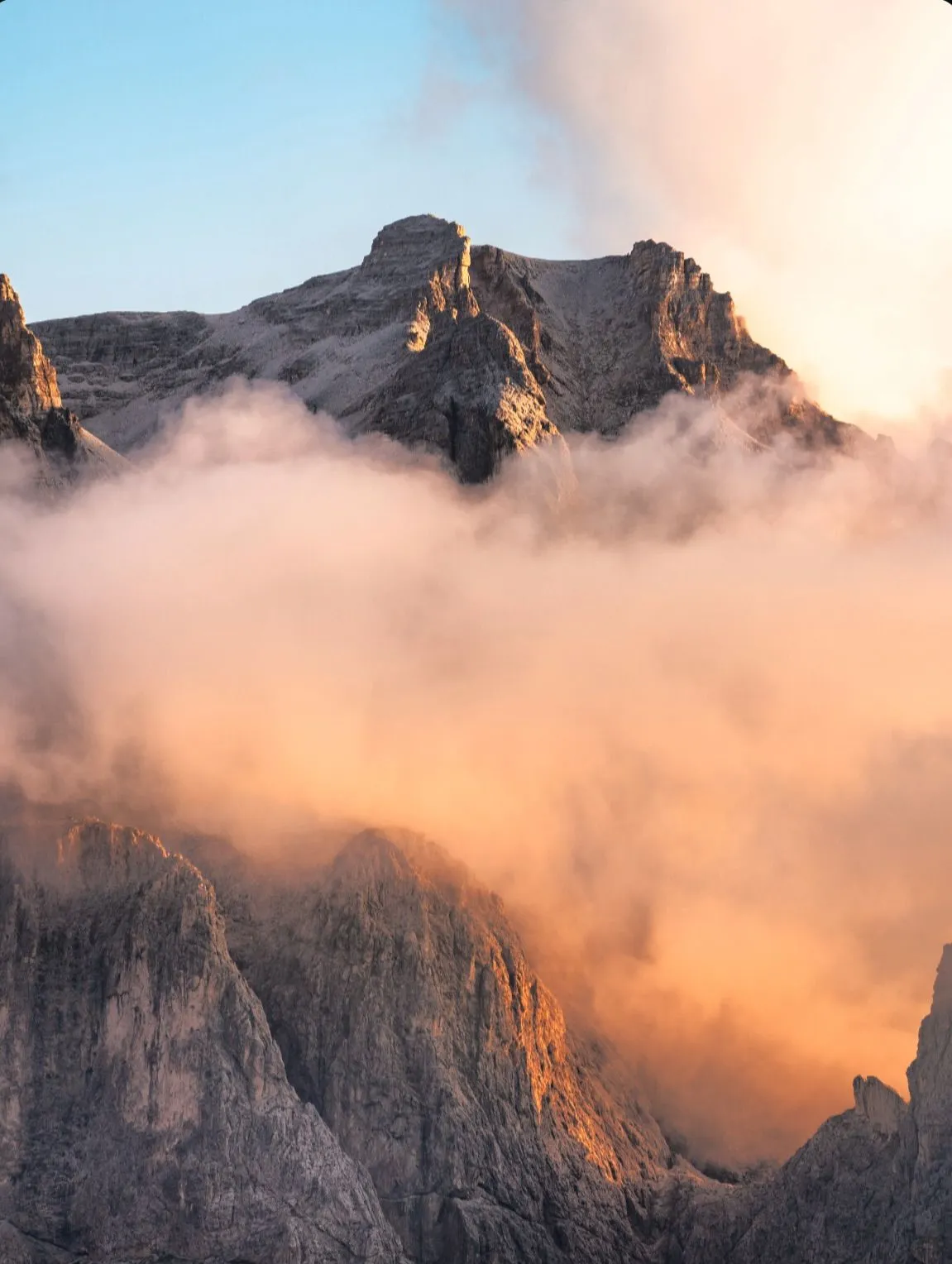 Pink alpenglow on the limestone cliffs of the Dolomites at sunset