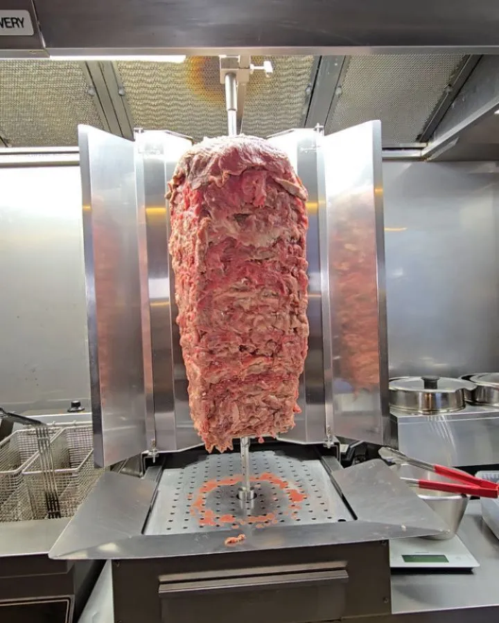 Chef rolling a fresh durum kebab with salad and dressing in Copenhagen