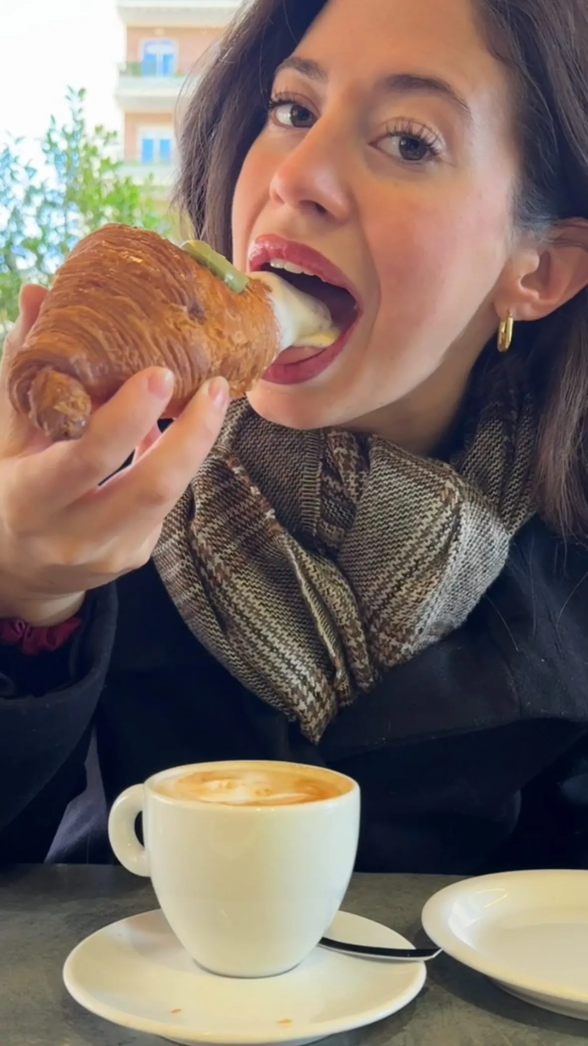 Fresh gluten free cornetto pastry and cappuccino on wooden table