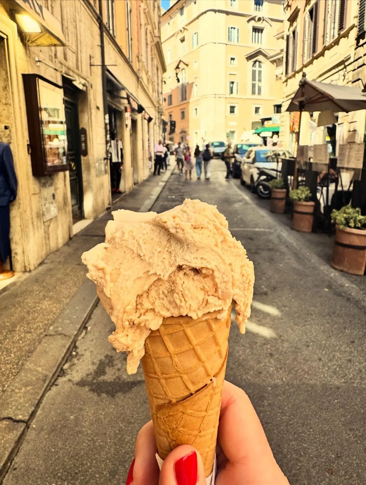 Hand holding artisan gluten free pistachio gelato on a Roman street