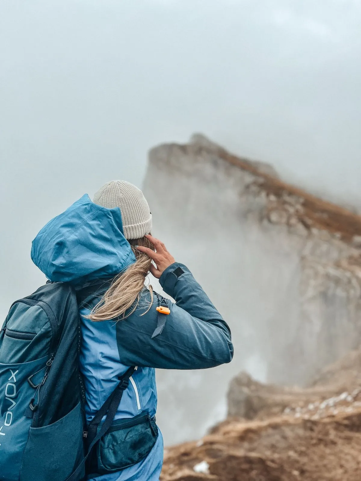 Hiker overlooking the Seceda peaks in the Dolomites during early autumn