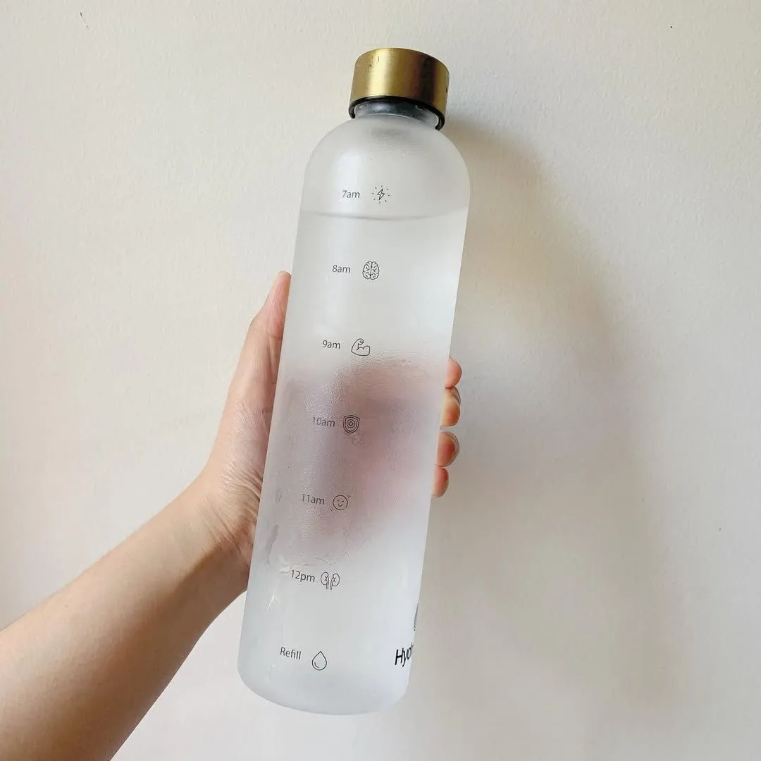 A hand holding a water bottle in the Omani desert heat