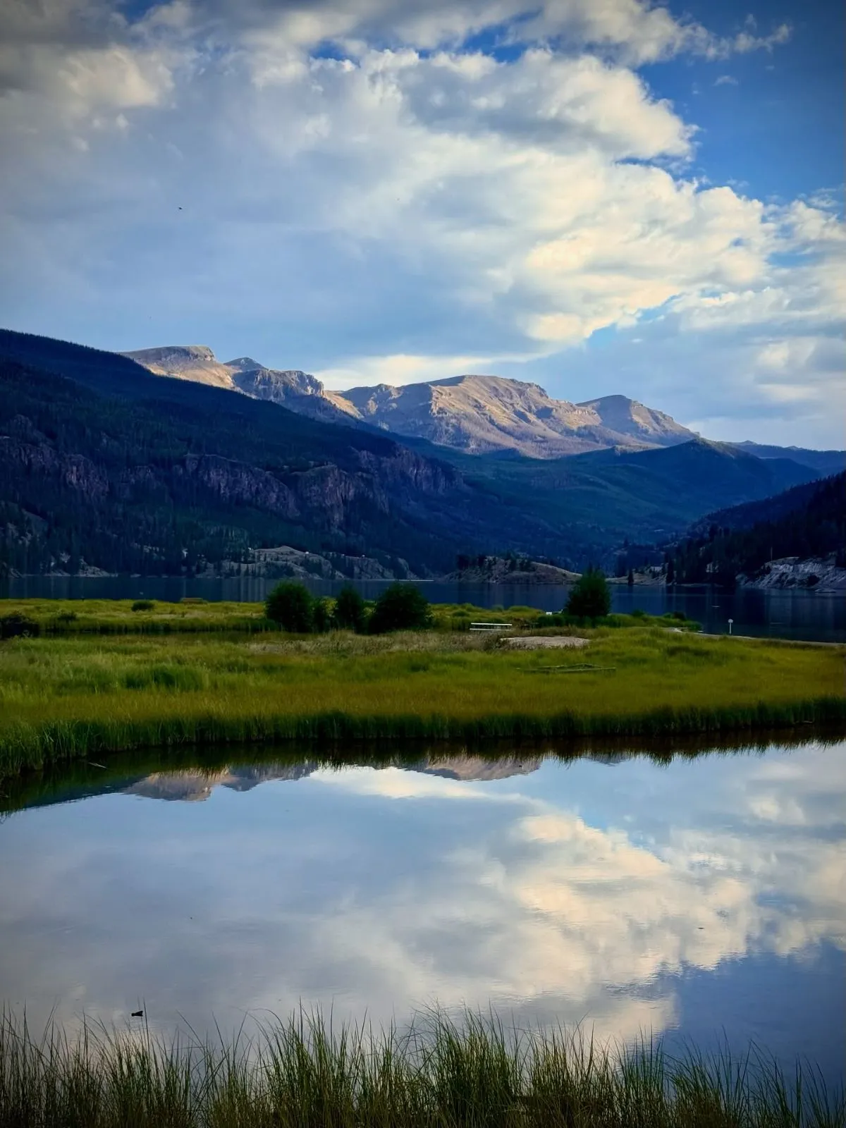 Reflective blue waters of Lake San Cristobal surrounded by pines