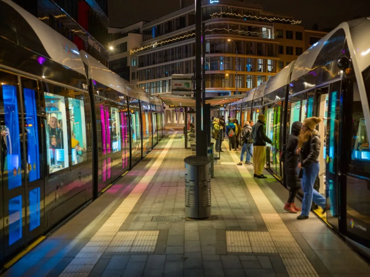 Modern tram traveling through Luxembourg City green streets