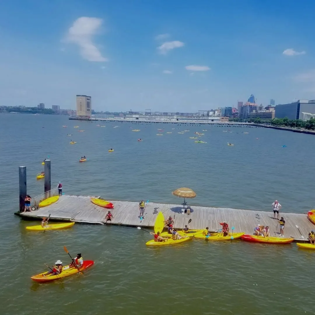 Colorful kayaks on the Hudson River at Pier 26 with the Manhattan skyline and Freedom Tower in the background