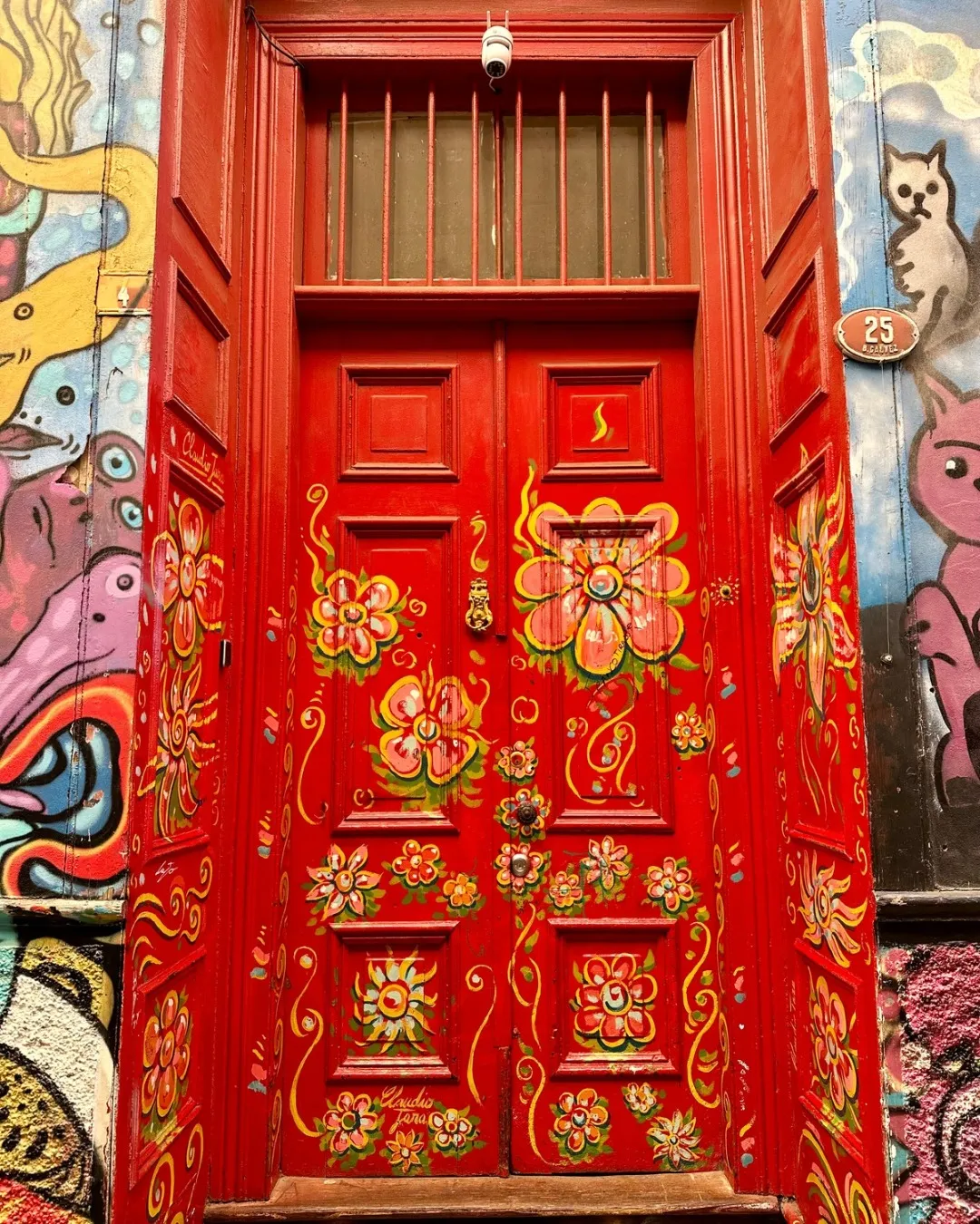 Bright red door surrounded by street art in Cerro Concepcion Valparaiso