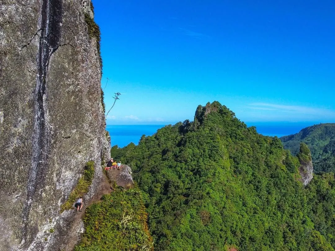 Hiker looking at the landscape from the base of The Needle in Rarotonga