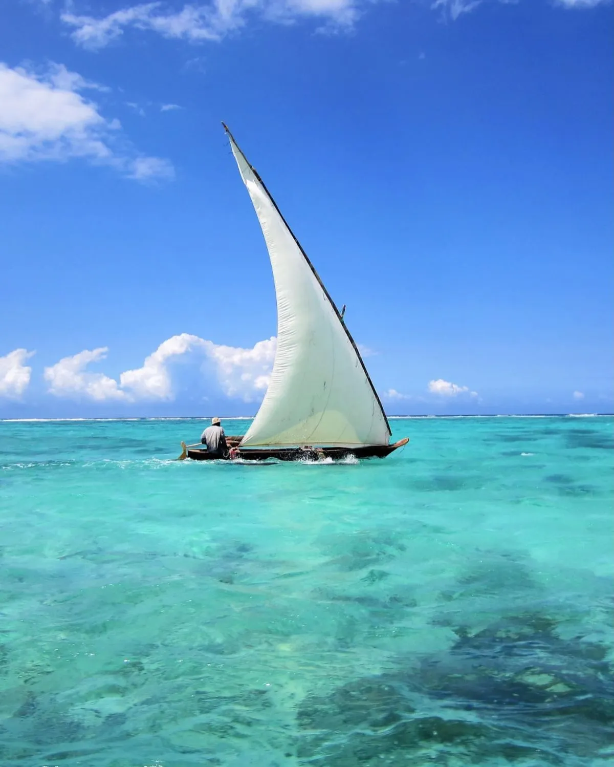 Traditional dhow boat sailing near Stone Town Zanzibar coastline
