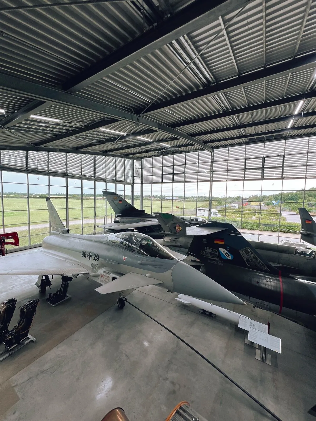 Vintage propeller planes displayed inside the historic Flugwerft Schleissheim hangar