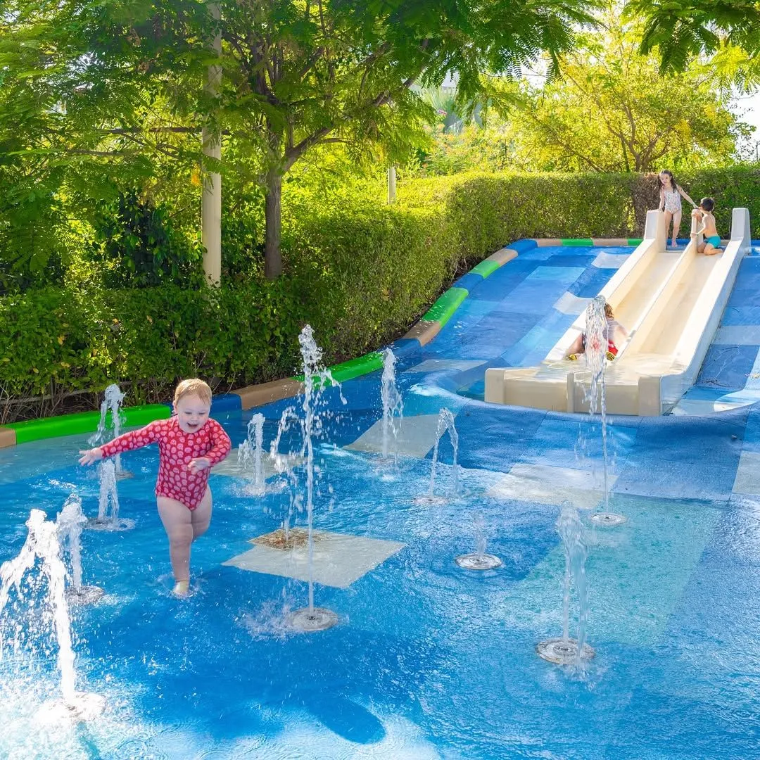 Toddler hands playing with water jets and boats at OliOli water gallery