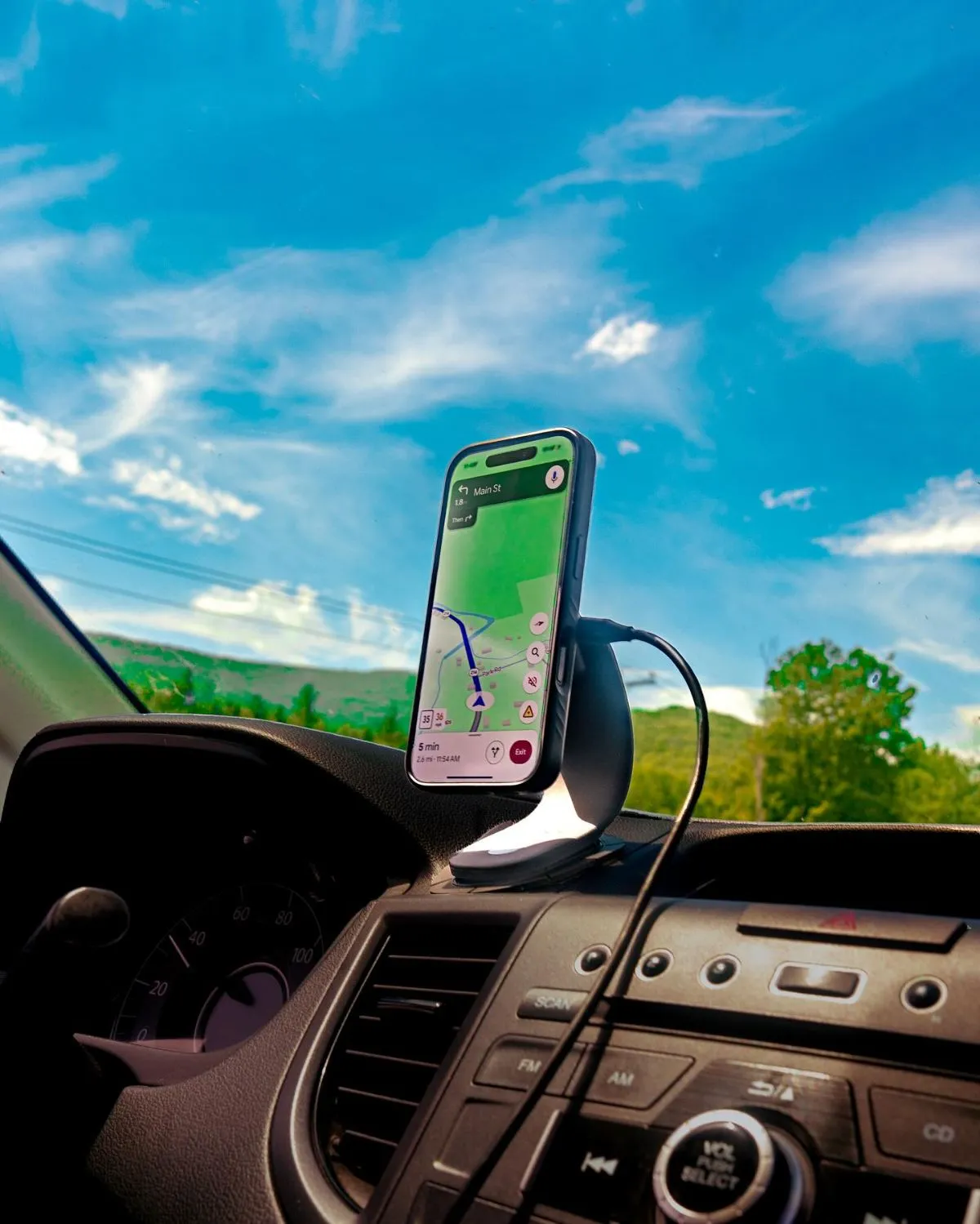 Smartphone on dashboard mount during a road trip through French countryside