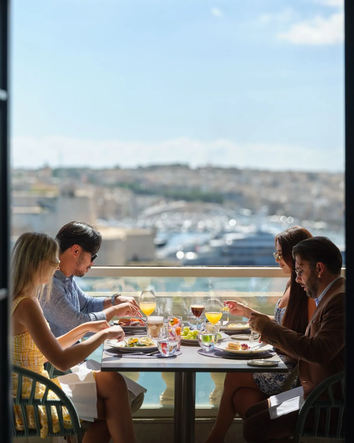 Waiter pouring wine at a dinner table overlooking the Grand Harbour Malta