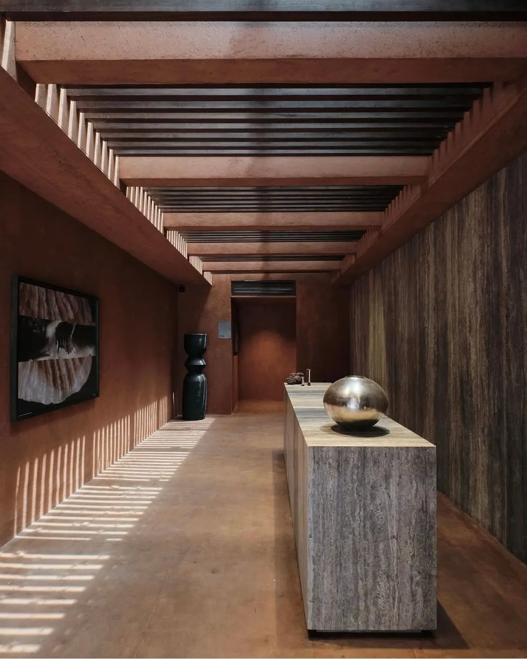 A minimalist concrete hallway with natural light and shadows in Further Hotel.