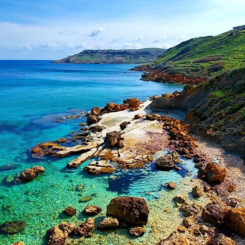 A scenic hiking trail winding along the high limestone cliffs of Ghajn Barrani in Gozo.