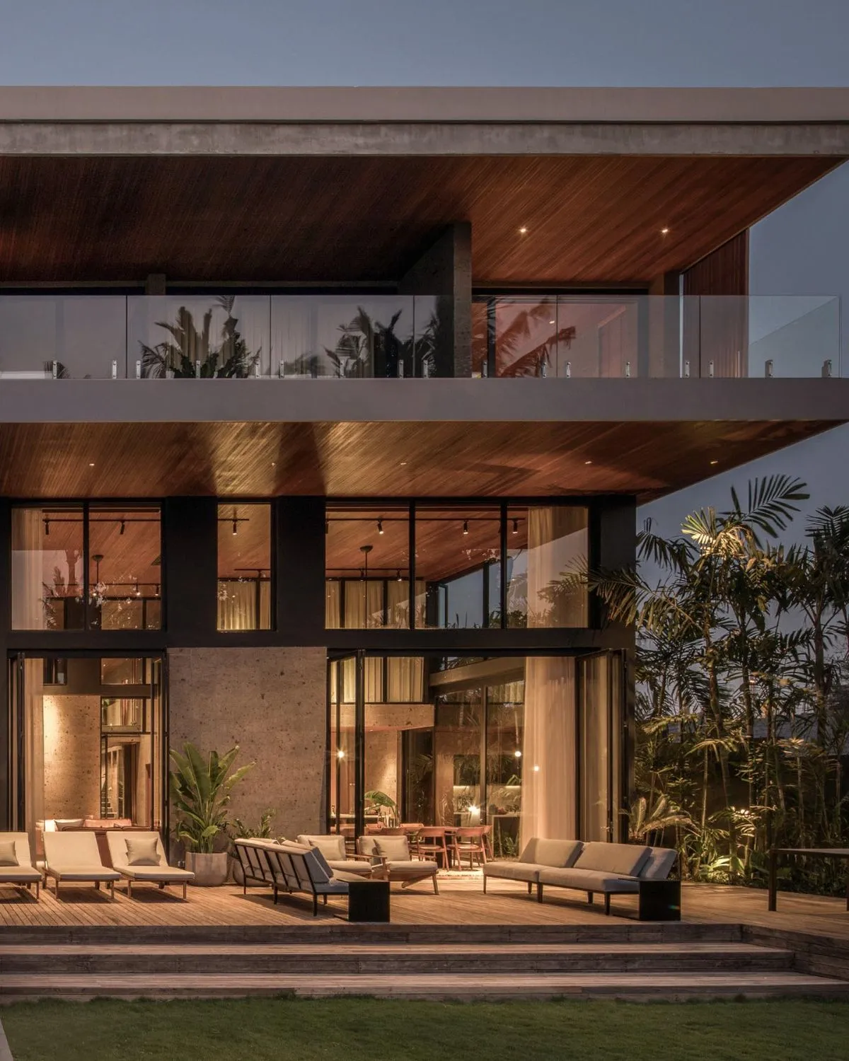 Secluded minimalist concrete villa with floor-to-ceiling windows overlooking a tropical river in Pererenan Bali