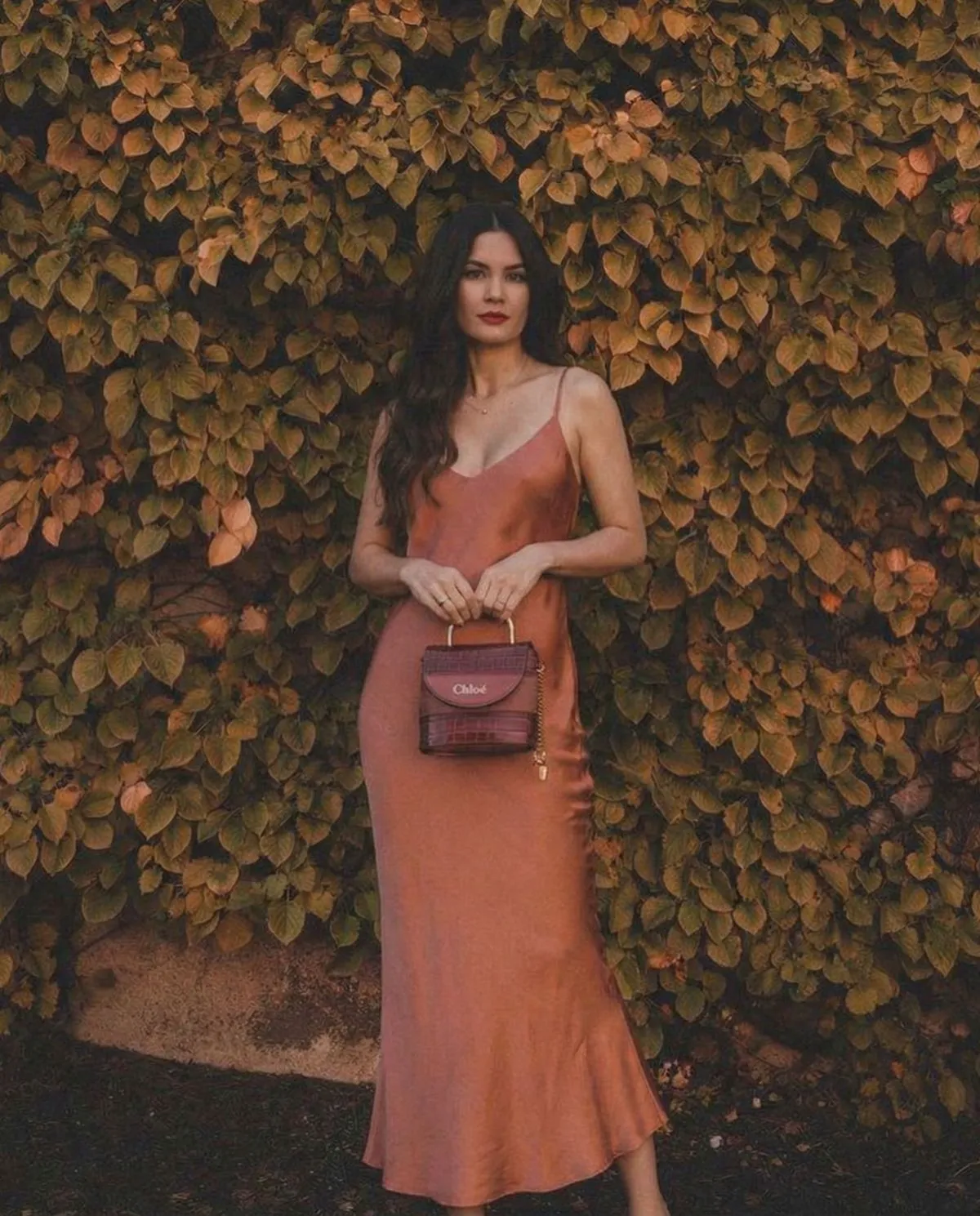 Woman wearing a champagne satin slip dress walking in Le Marais Paris