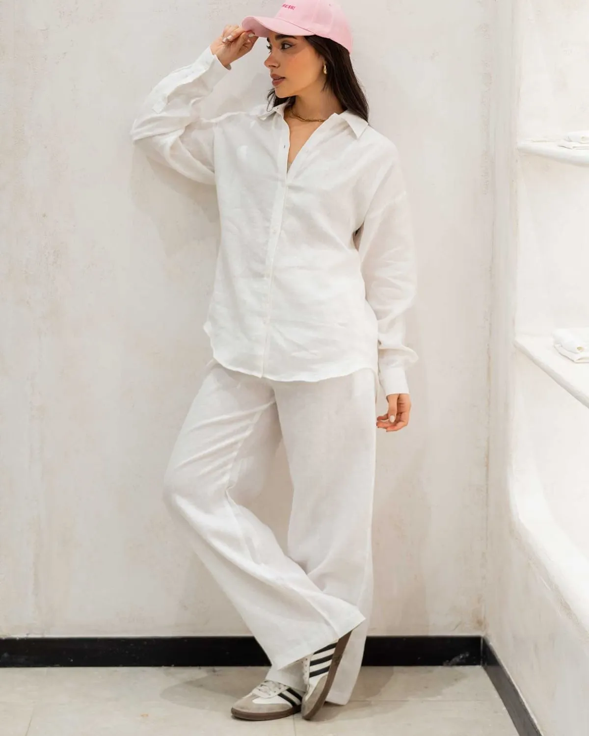 Woman wearing white linen shirt and tailored trousers in Le Marais Paris