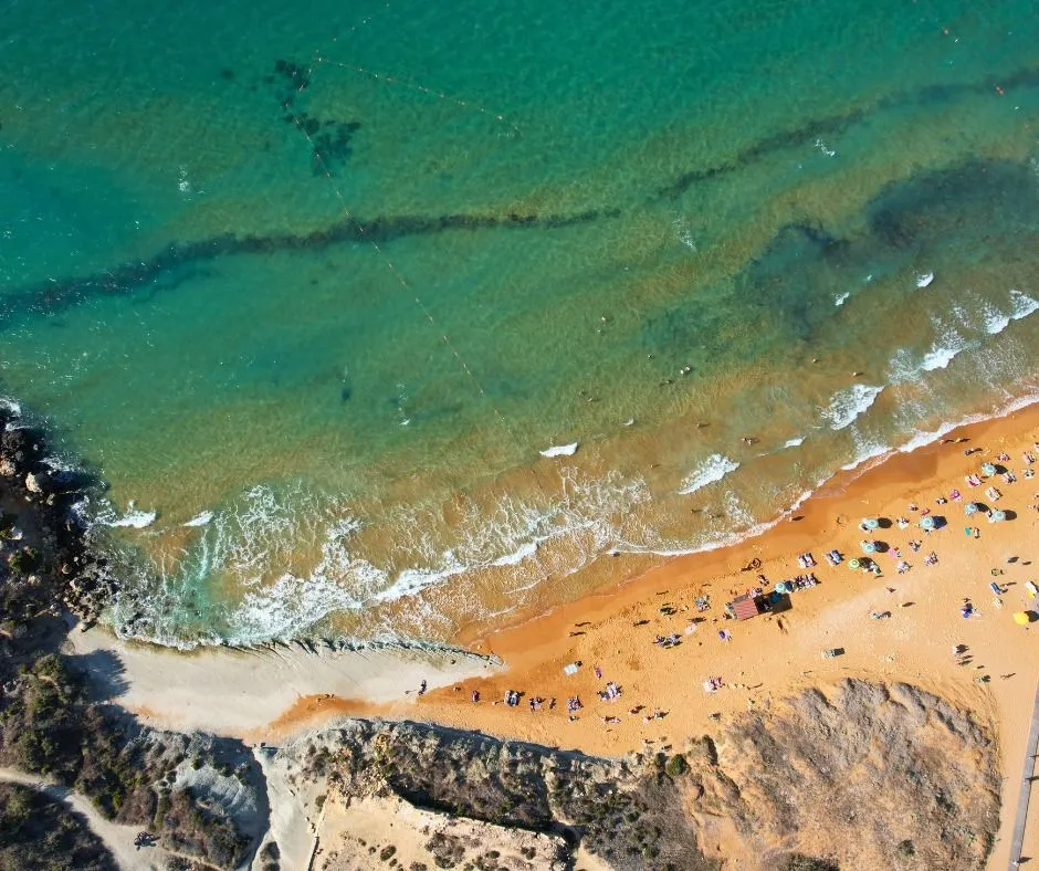 The famous red sand beach of Ramla Bay in Gozo viewed from a high trail.