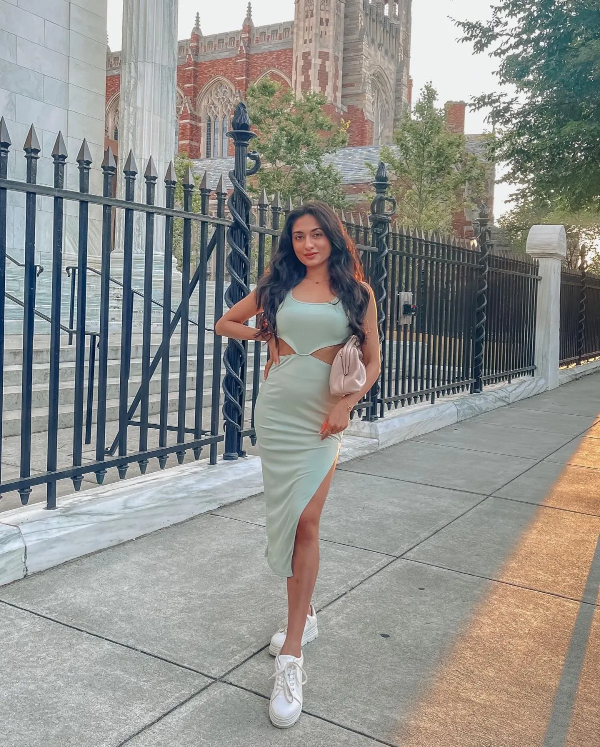 Fashionable traveler wearing white sneakers with a summer dress in a Paris park