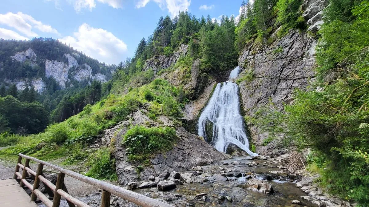 A view of the towering limestone walls and suspension bridge at Cheile Turzii, a popular beginner hiking trail in the Apuseni Mountains, Romania.