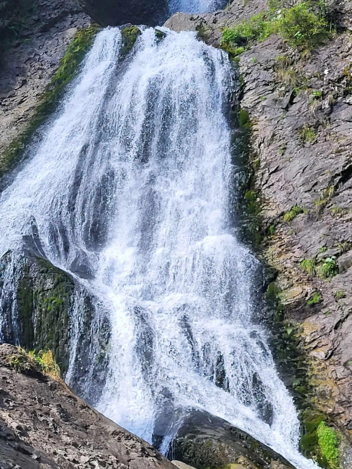 White water cascading over dark limestone rocks at Valul Miresei waterfall