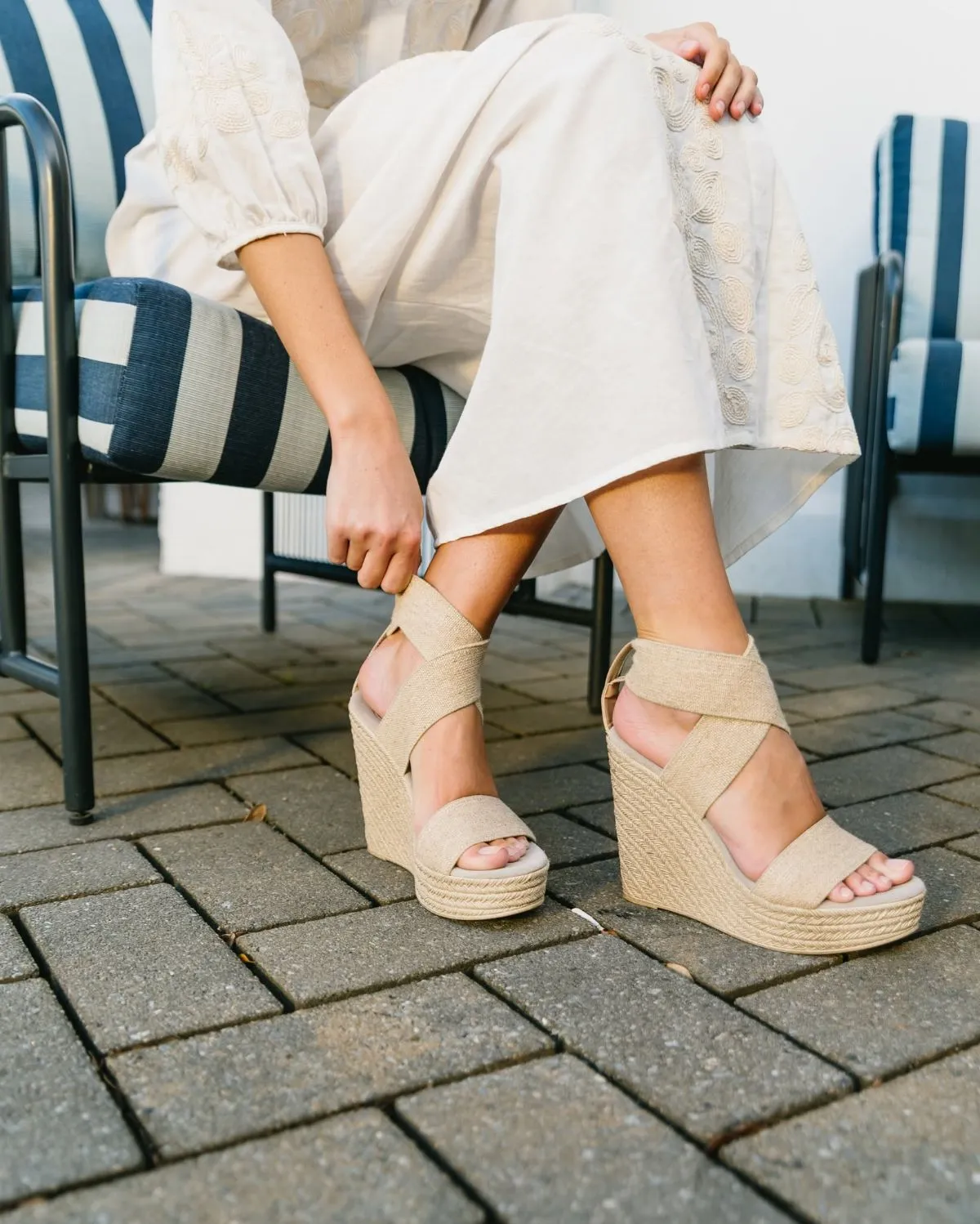 Close up of wedge espadrilles and basket of peonies in Paris