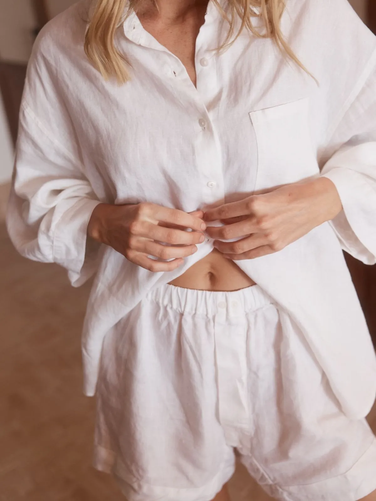 Close up of white linen shirt texture with gold accessories