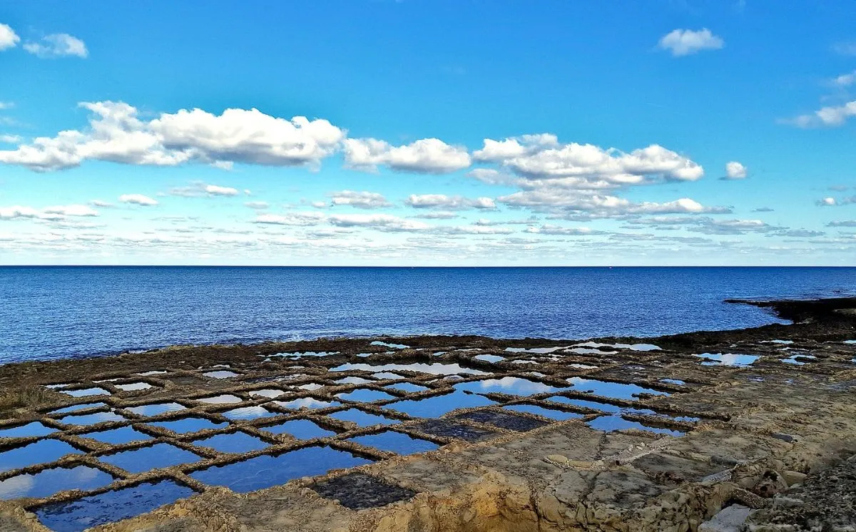 Geometric salt pans carved into the rock along the Gozo coast near Marsalforn.