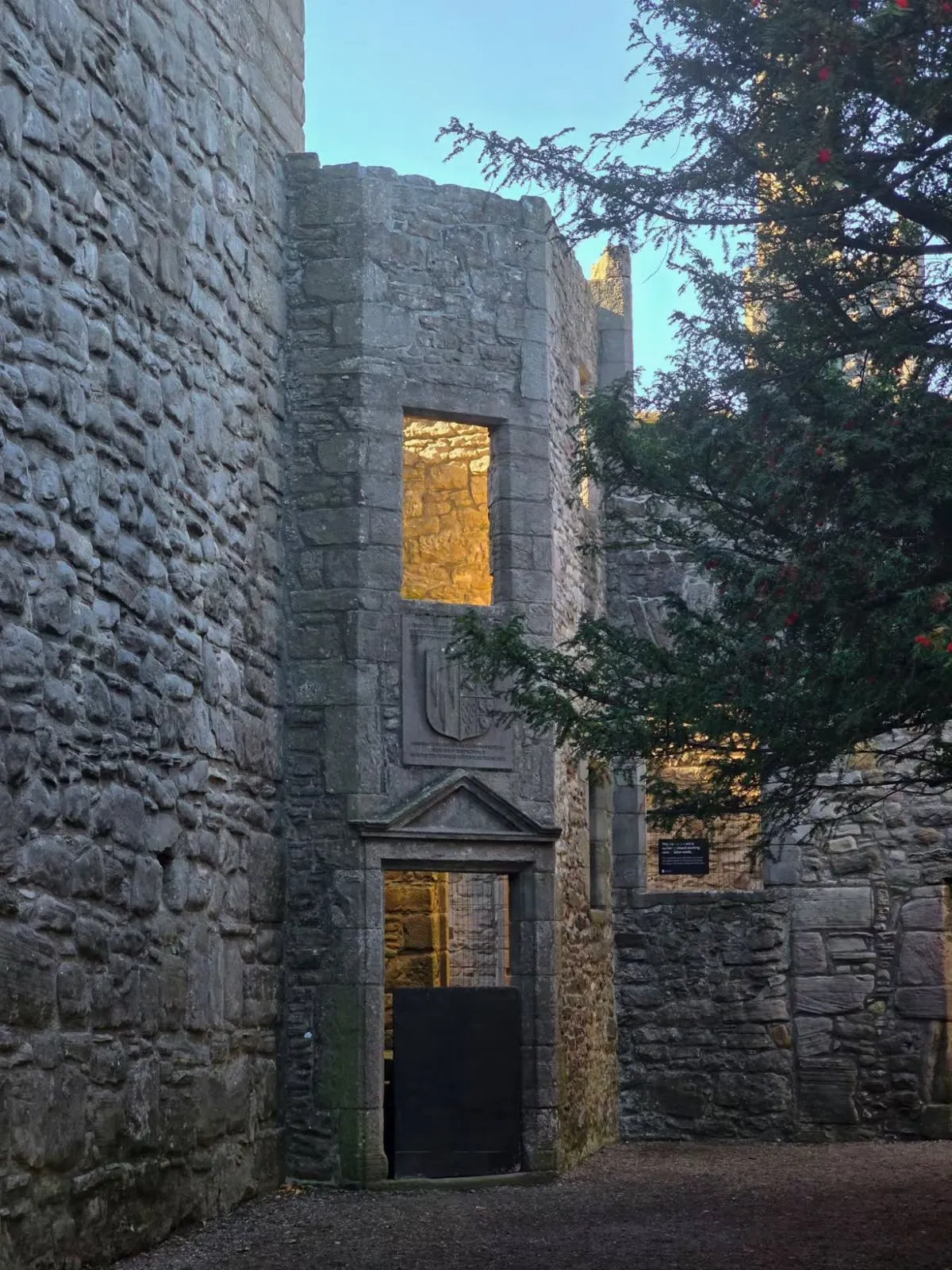 Inner stone courtyard of Craigmillar Castle with mossy walls and arched doorways