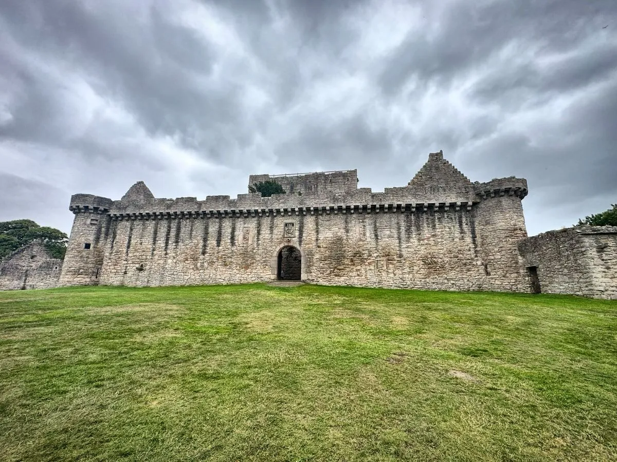 Stone ruins of Craigmillar Castle surrounded by lush greenery near Edinburgh