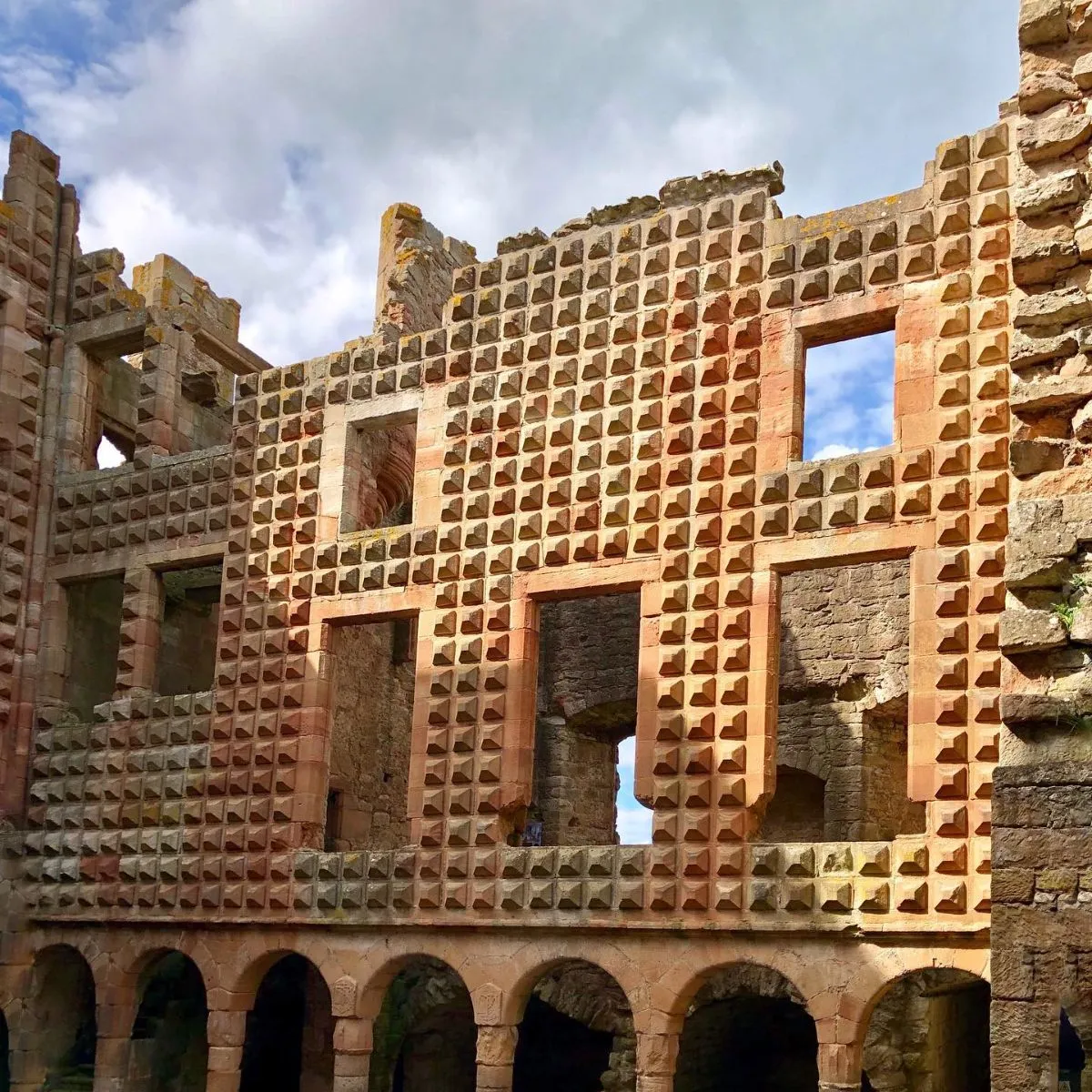 Lush green landscape surrounding the historic ruins of Crichton Castle in Midlothian
