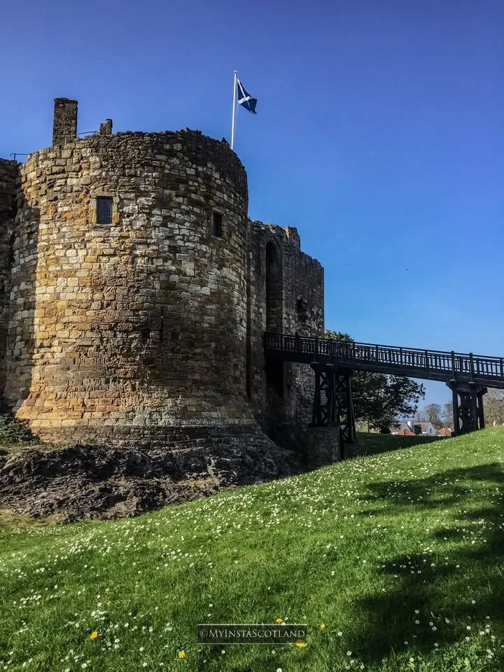Lush green gardens surrounding the medieval ruins of Dirleton Castle near Edinburgh