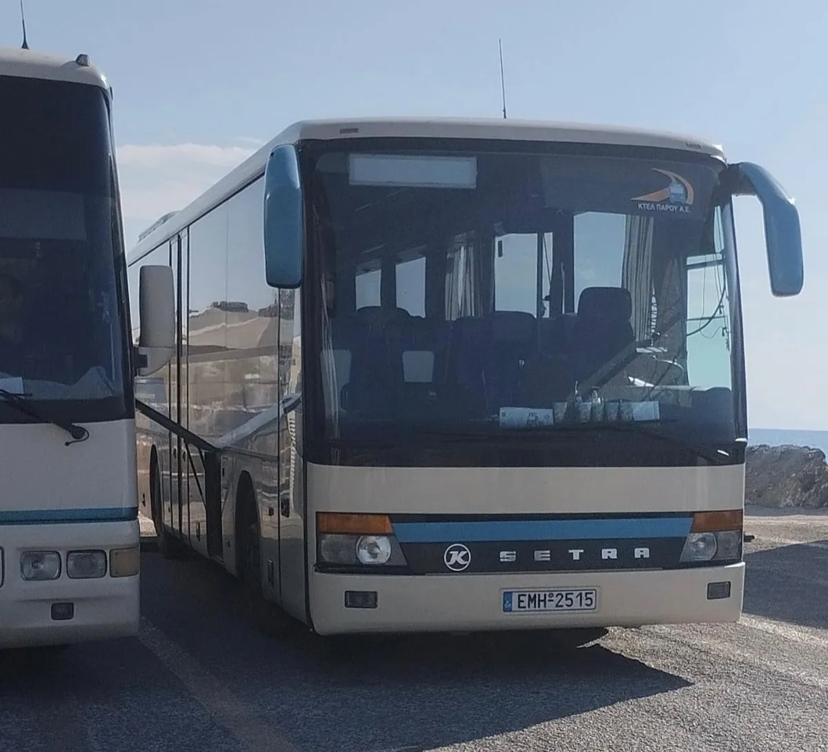 Blue KTEL bus driving along the scenic coast of Paros island
