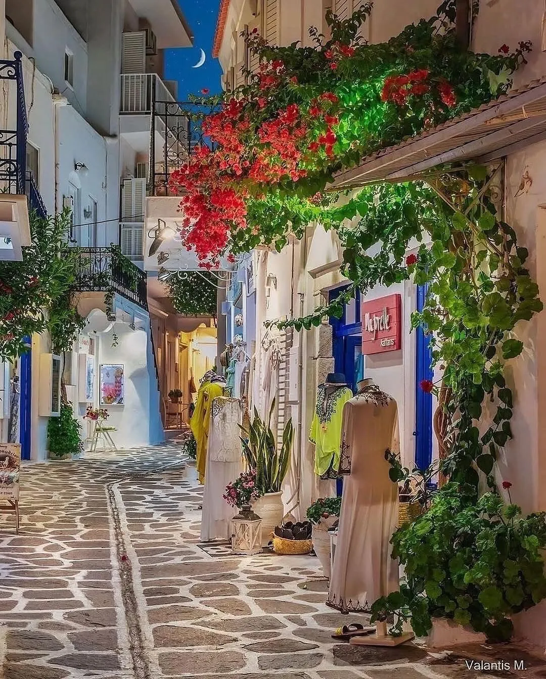 Nighttime cobblestone street in Paros with a taxi waiting