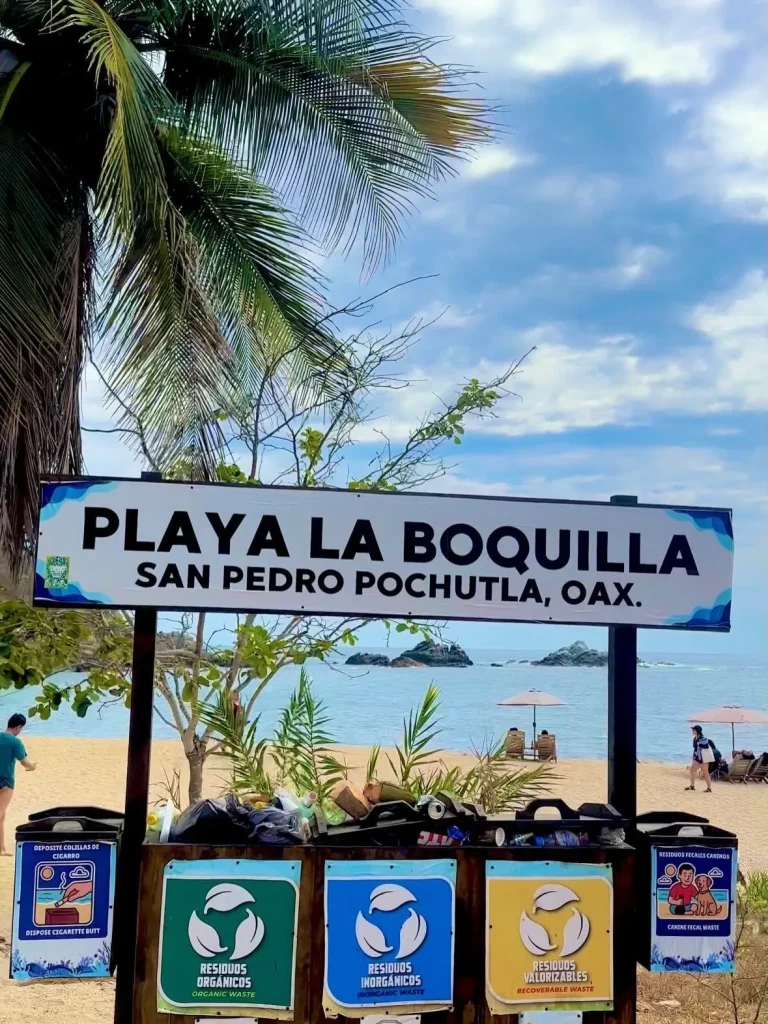 A quiet golden sand crescent beach surrounded by cliffs at Playa La Boquilla in Oaxaca