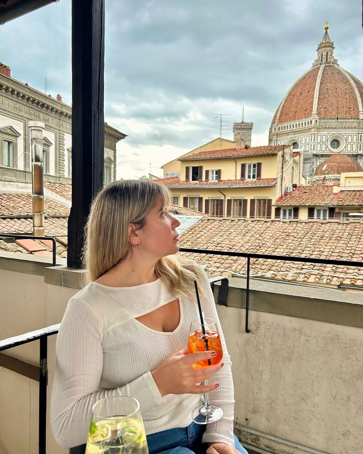 People enjoying coffee on a rooftop terrace overlooking the Florence Cathedral dome