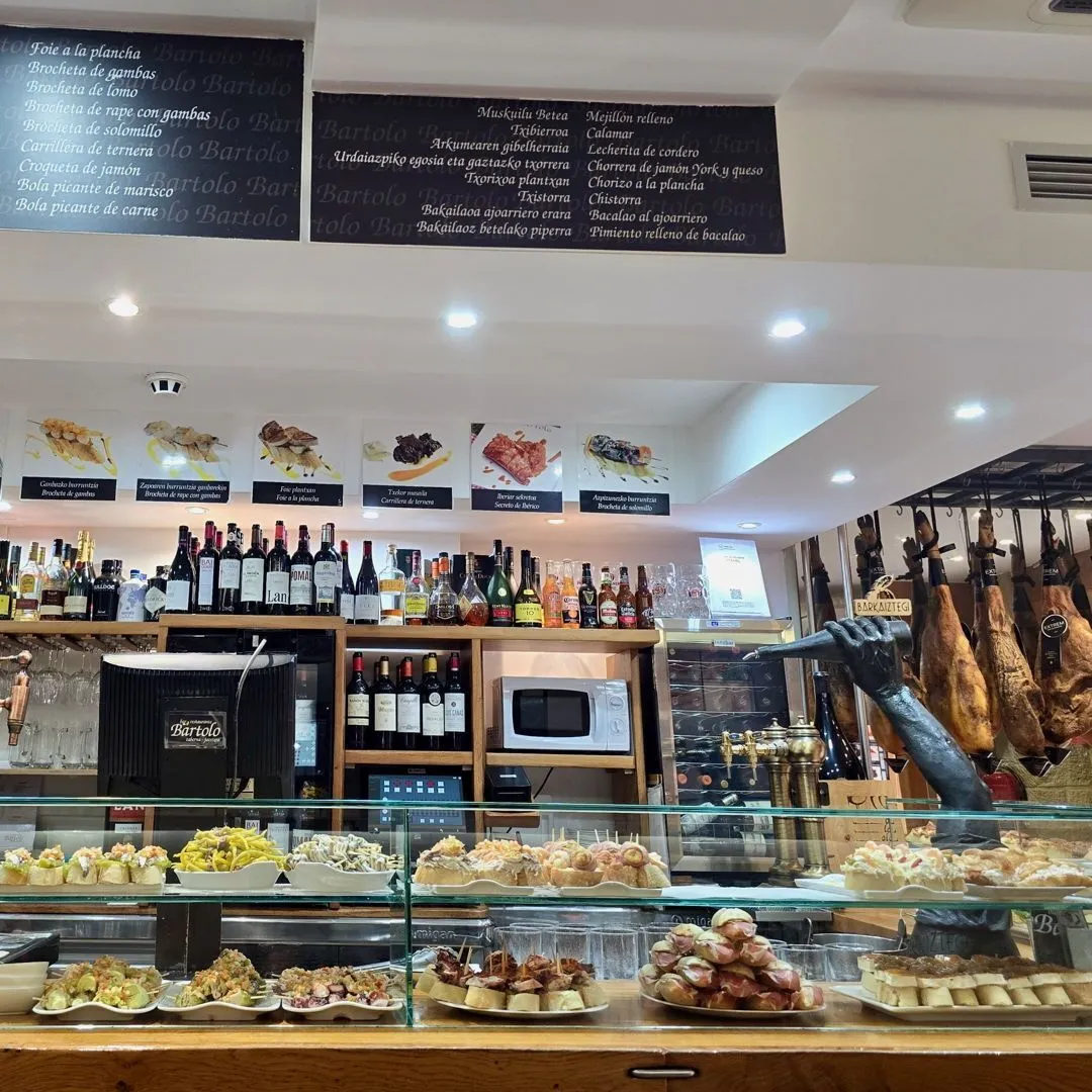 Colorful Basque pintxos on a rustic wooden bar in San Sebastian