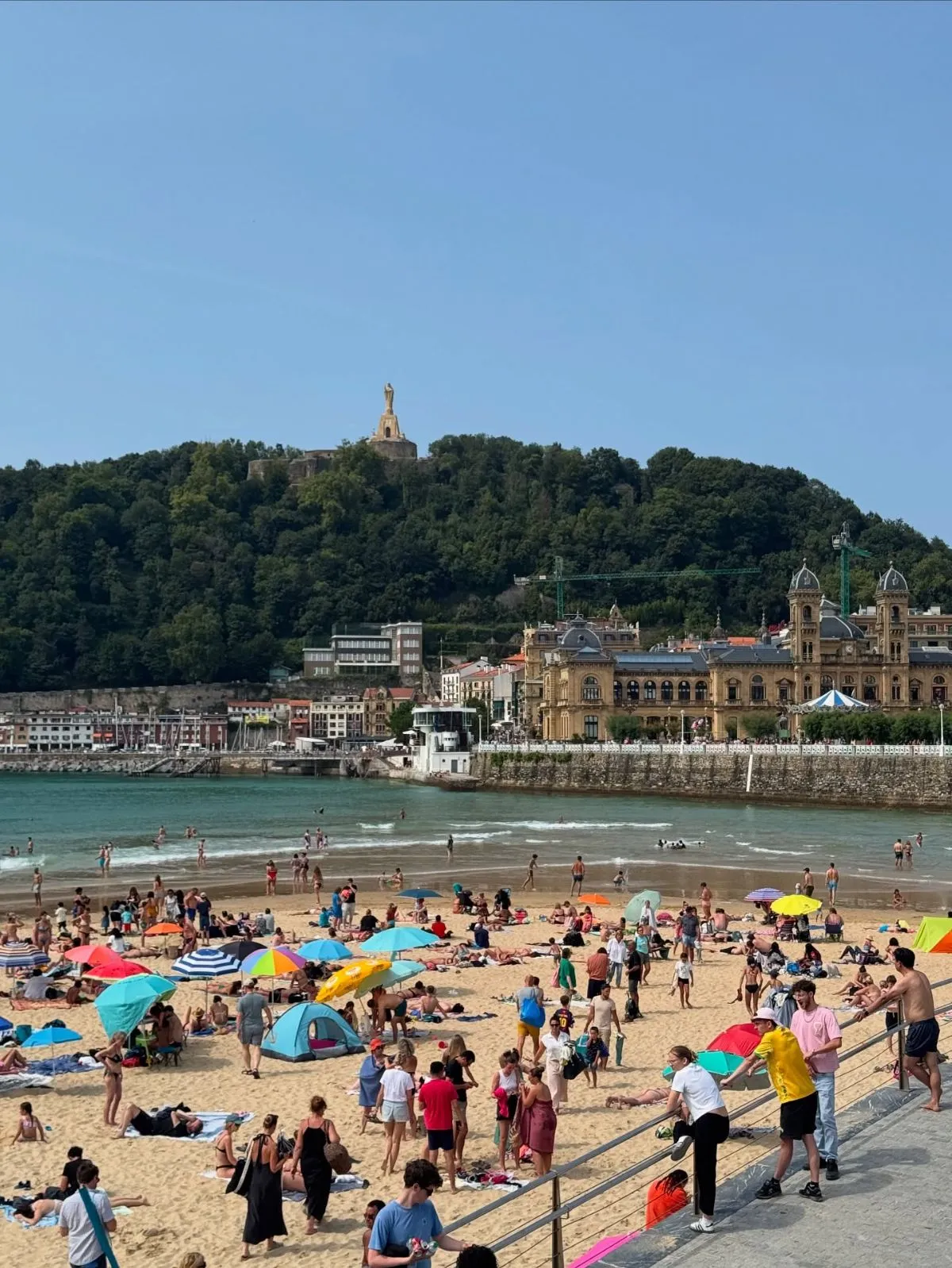 Surfers catching golden hour waves at La Zurriola beach in San Sebastian