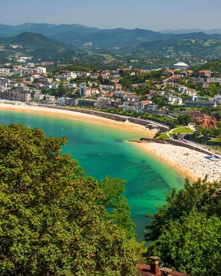 A romantic couple overlooking La Zurriola beach and the San Sebastián coastline during a Basque Country adventure honeymoon.