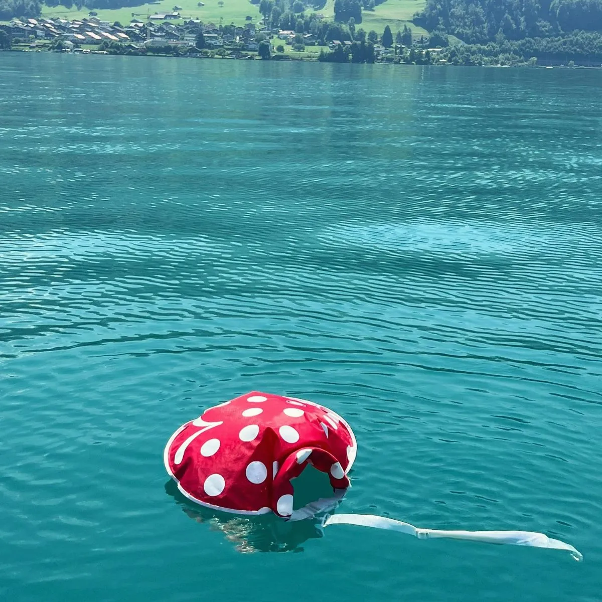 Brightly colored Wickelfisch swim bags floating on the turquoise Aare River in Bern