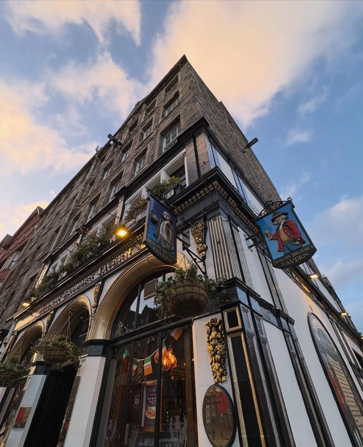 Dark wooden exterior of a traditional Edinburgh pub at dusk