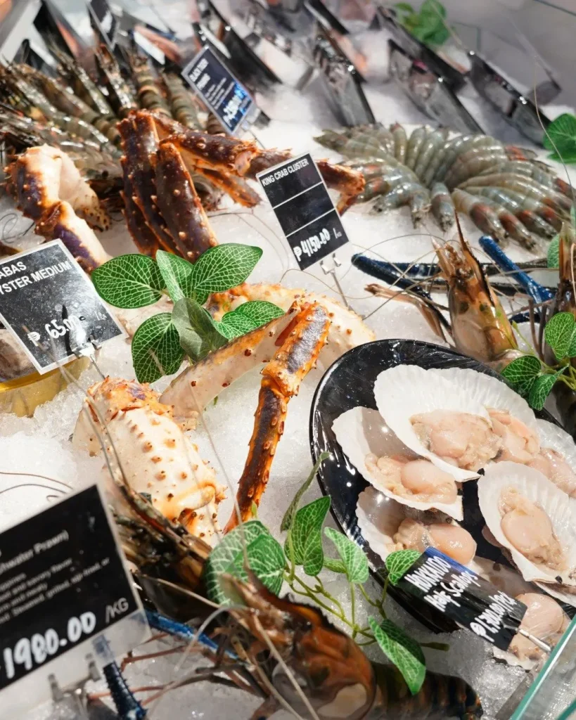 Rustic wooden tables serving fresh grilled seafood at Ganh Dau village