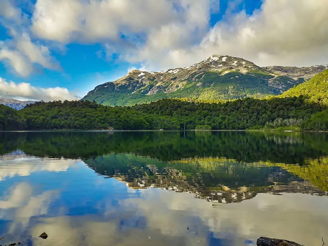 A peaceful glacial lake nestled among lenga forests in the Patagonian Andes near El Bolsón