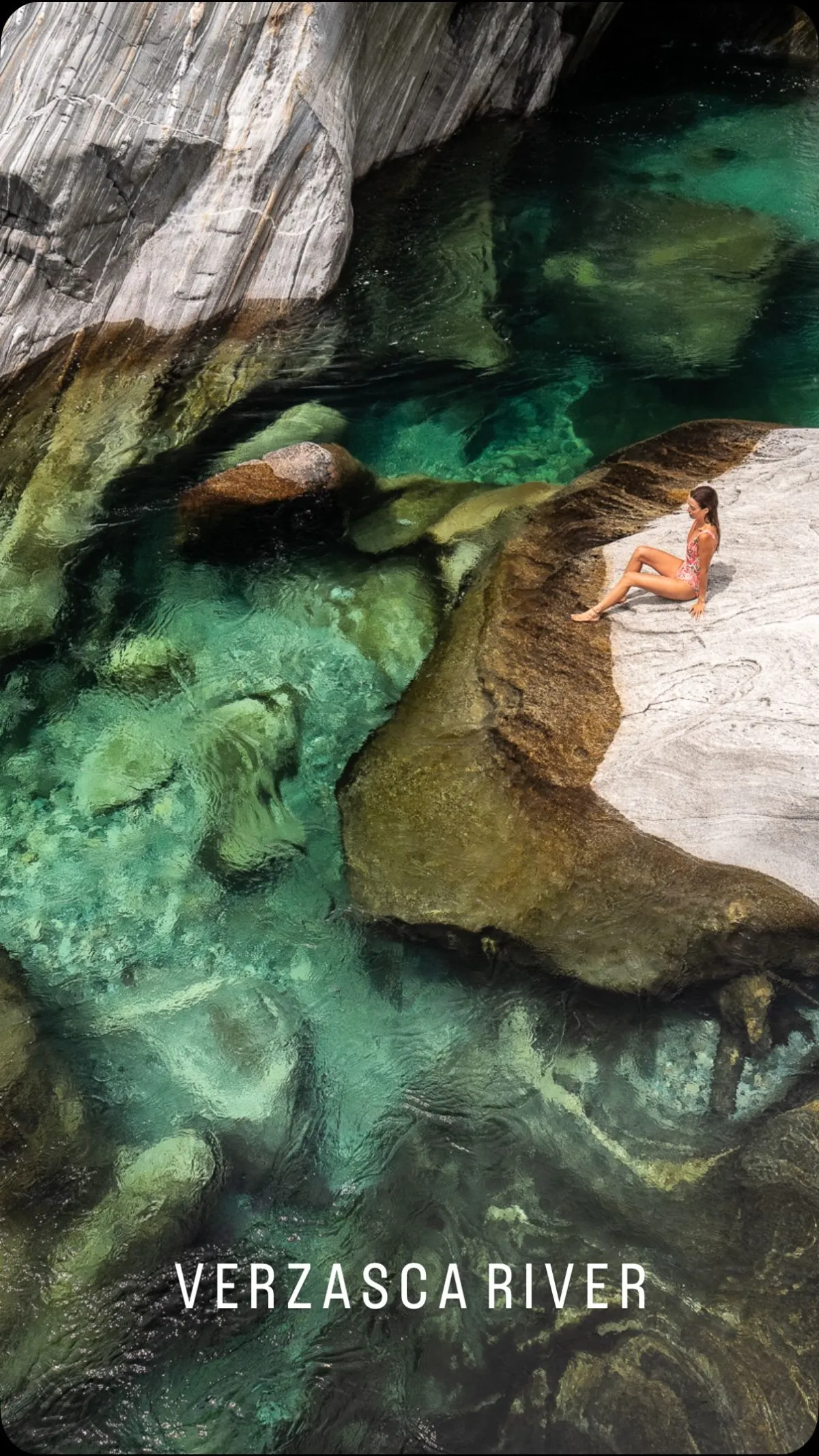 Scuba diver checking gear beside the emerald waters of Verzasca Valley