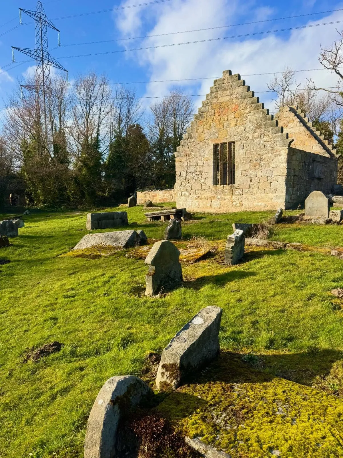 The roofless stone ruins of West Kirk church and ancient gravestones in Culross Scotland.