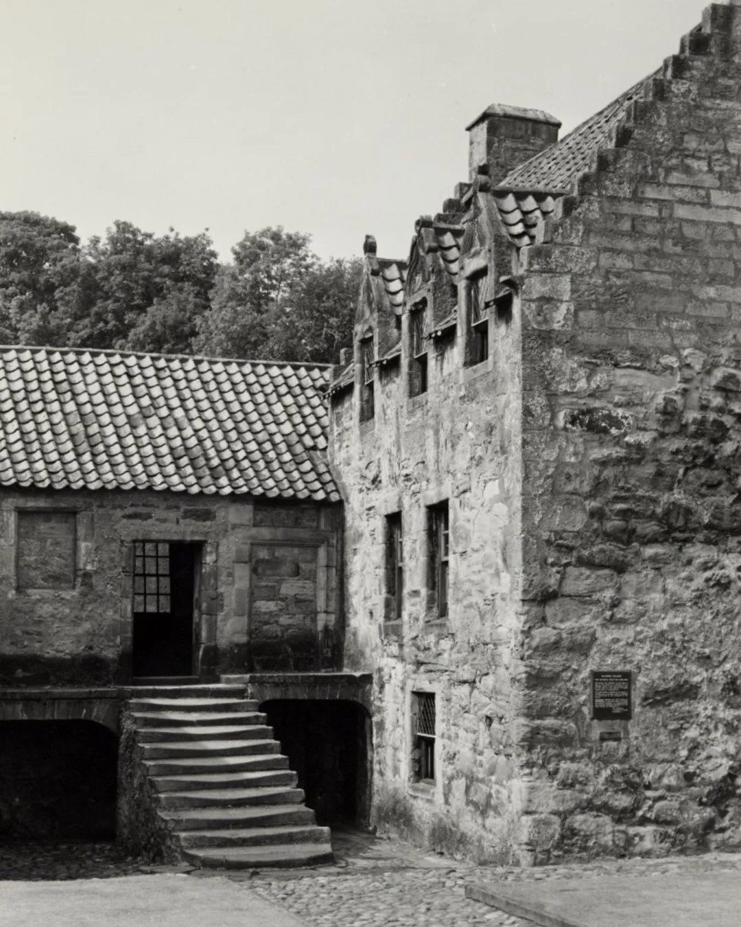 The stone-walled kitchen inside Culross Palace featuring original iron cookware