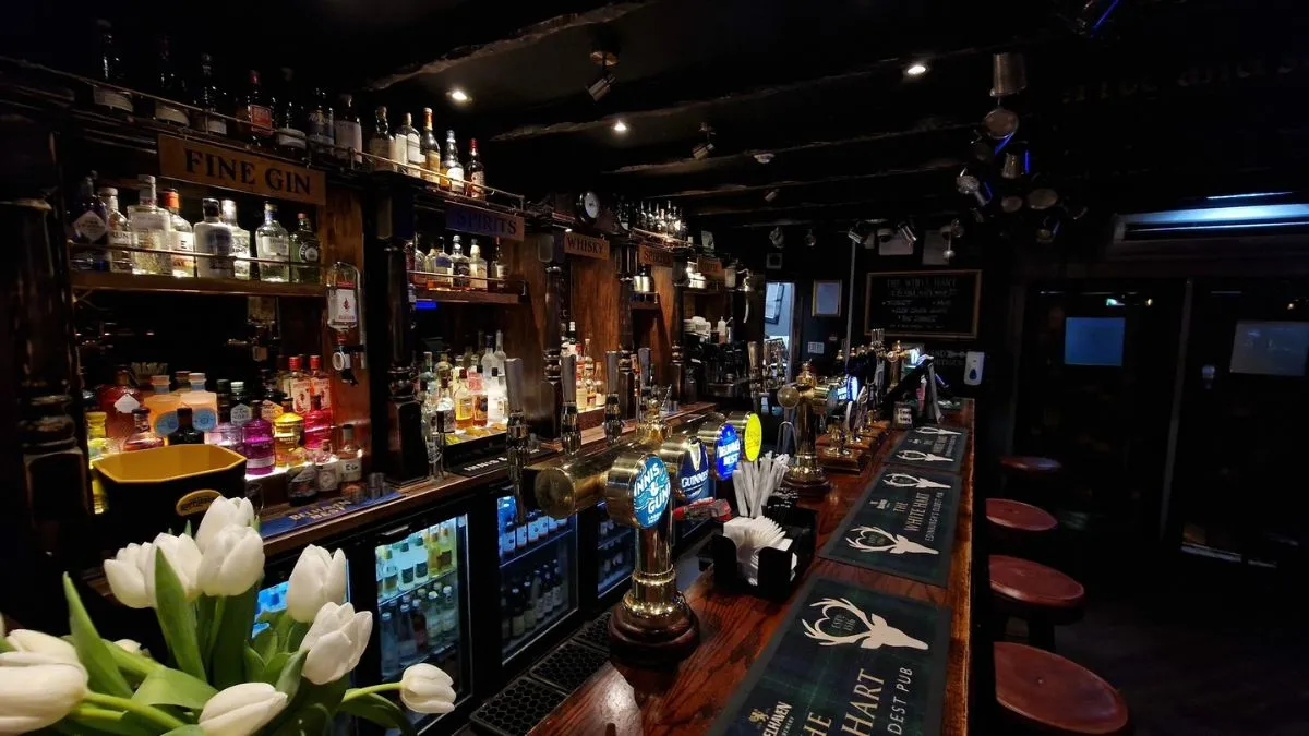 Cozy interior of The White Hart Inn in Edinburgh featuring wooden beams and a fireplace